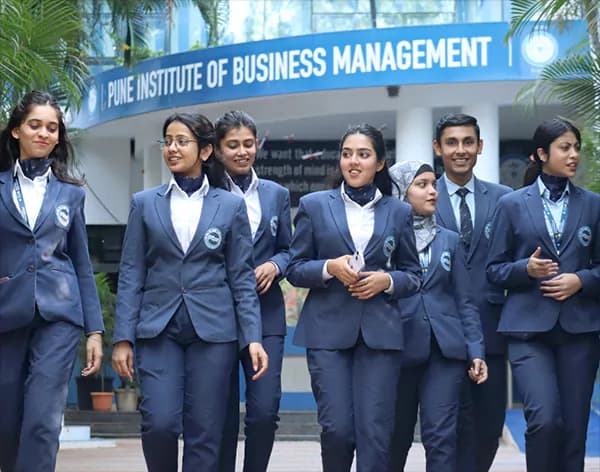 PIBM students in institute blazers walking past the Pune Institute of Business Management campus entrance
